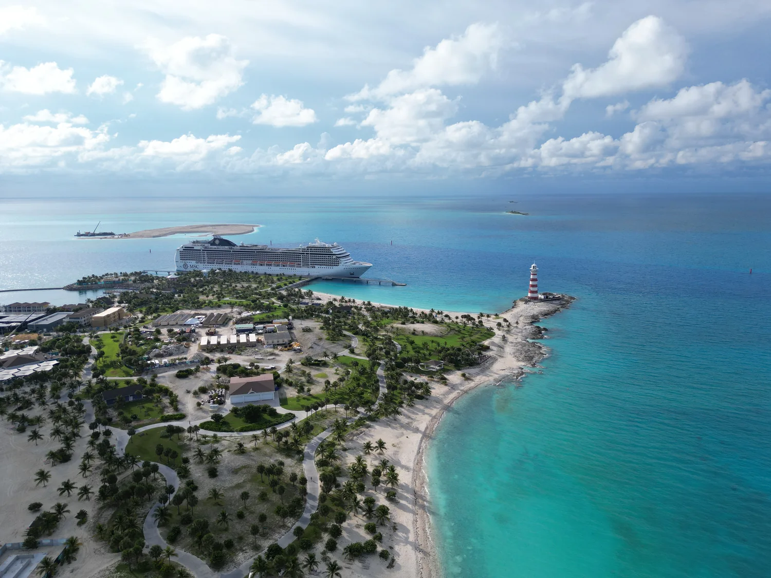 Aerial view of Ocean Cay's shoreline, lighthouse, and docked MSC ship