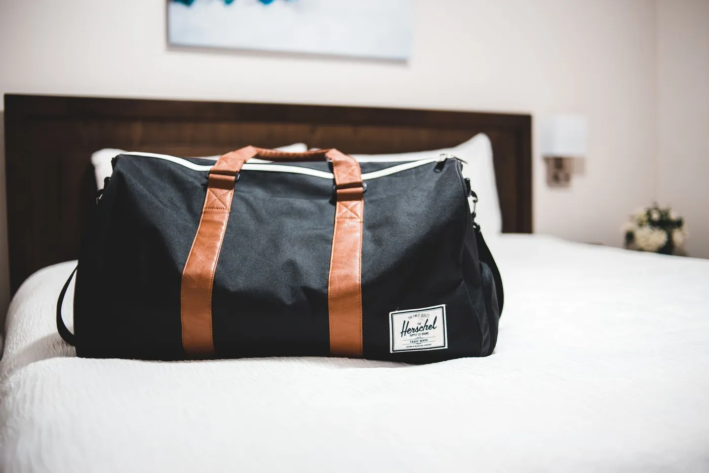 Packed duffel bag resting on a hotel bed