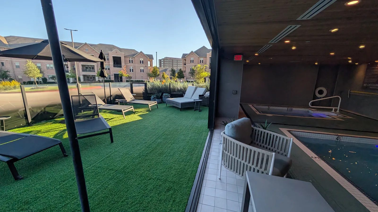 Outdoor turf patio with loungers, open to the indoor pool.