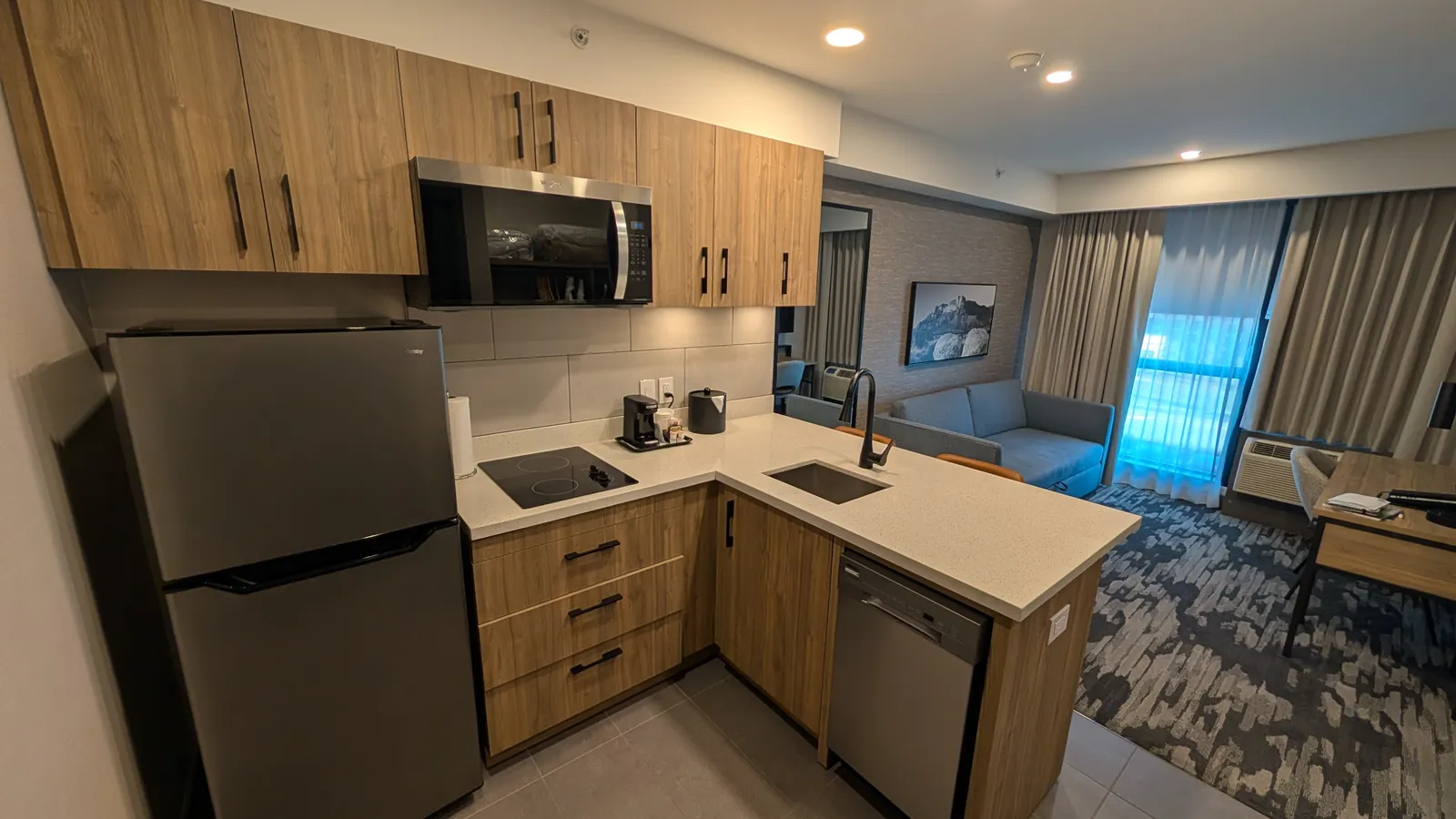 Suite kitchen with the fridge, cooktop, microwave, and peninsula sink