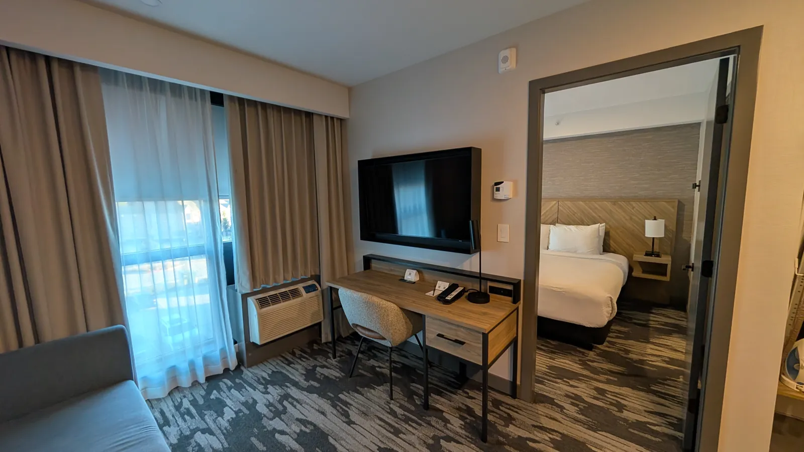 Living room with the desk and TV, looking into the king bedroom