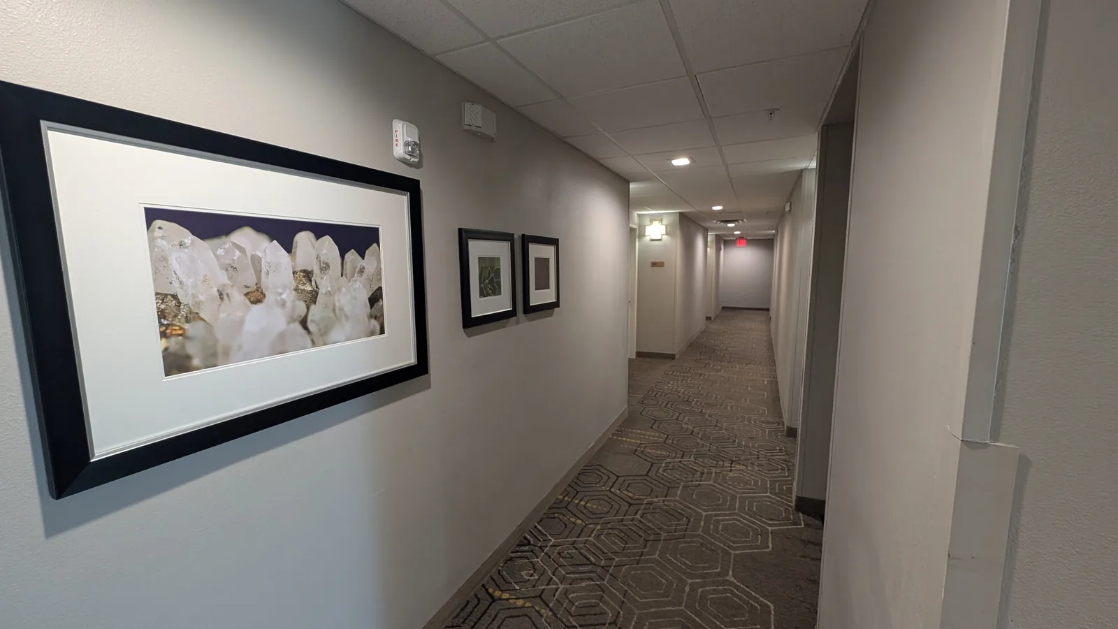 Framed artwork along a hotel hallway.